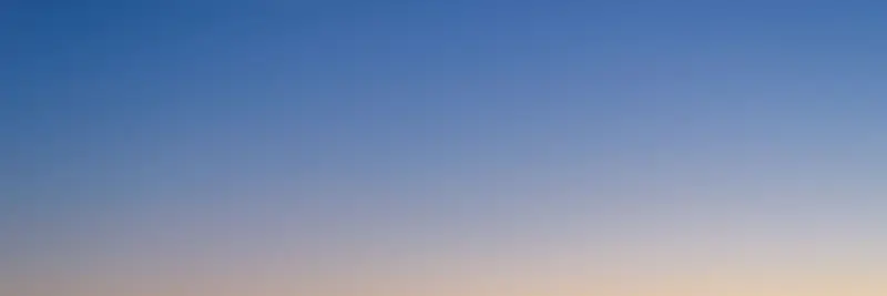 A sunset sky grading from orange through pink to deep blue