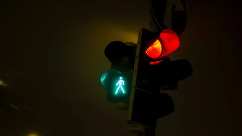 Traffic signals glowing against an evening sky