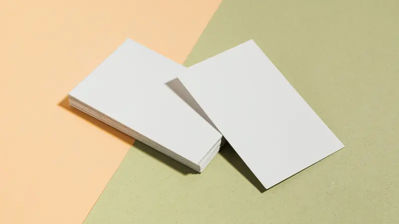 A printed business card resting on a textured surface