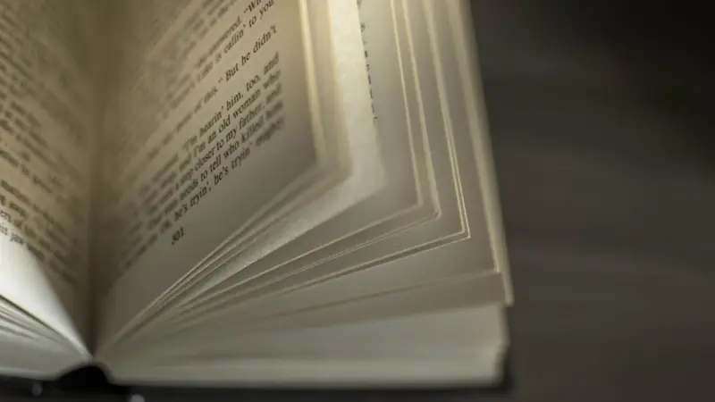 An open book resting on a table in a library reading room