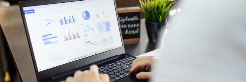 Charts and tabular data displayed on a laptop in an office