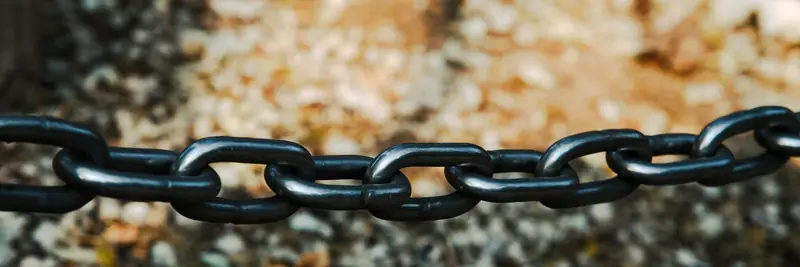 A close-up of interlocking metal chain links catching the light