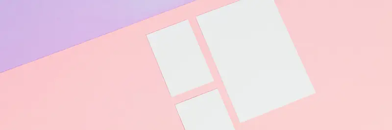Printed page layouts and design mock-ups spread across a studio table