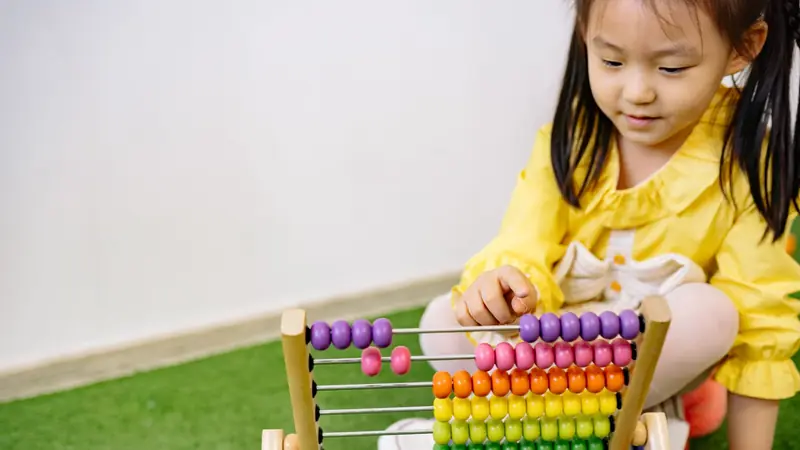 A wooden abacus with coloured counting beads on metal rods