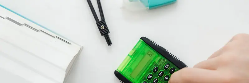 A pocket calculator and handwritten figures on a notepad