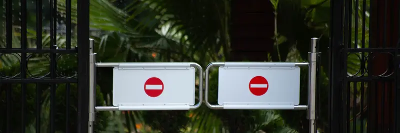 A barrier arm controlling vehicle access at an entrance
