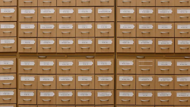 The wooden drawers of an old library card catalogue