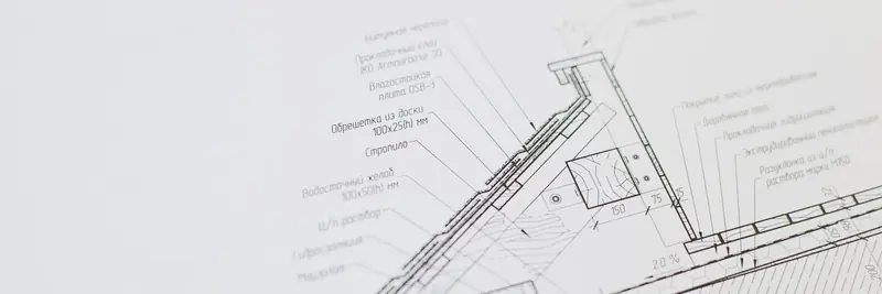 Technical architectural blueprints unrolled on a work table