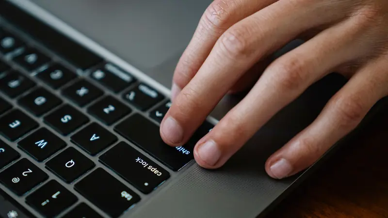 Hands resting on a keyboard with the shift key in focus