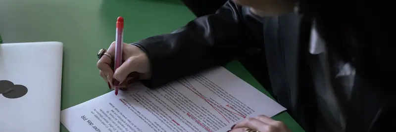 A printed manuscript marked up with a red editing pen