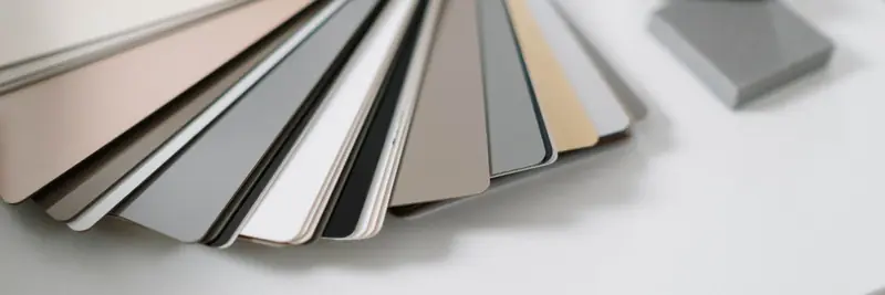 A designer's desk with colour swatches, a tablet and a keyboard